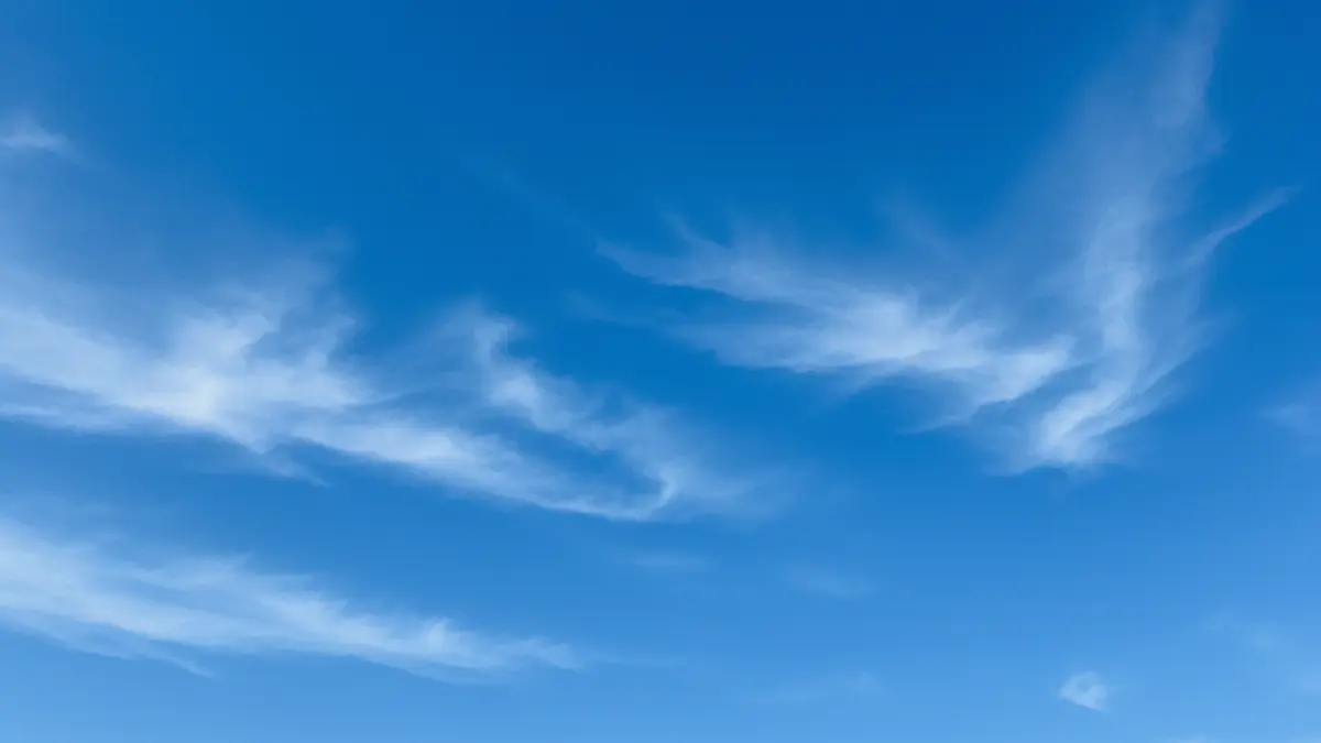 Ein weiter, tiefblauer Himmel an einem klaren Tag, durchzogen von wenigen, feinen Schleierwolken, der die Weite der Atmosphäre illustriert.